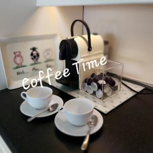una mesa con dos tazas y una señal de hora del café en Clover Cottage, en Sligo