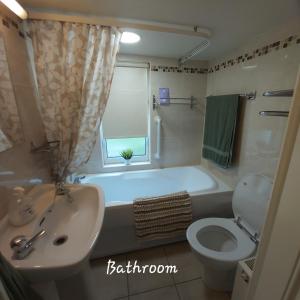 a bathroom with a tub and a sink and a toilet at Clover Cottage in Sligo