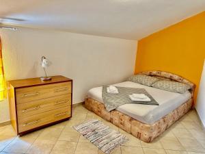a small bedroom with a bed and a dresser at Apartments Novoselic in Vir