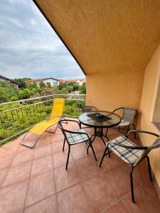 a patio with a table and chairs on a balcony at Apartments Novoselic in Vir