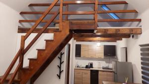 escalera de madera en una habitación con cocina en Casa nouă, en Sasca Montană