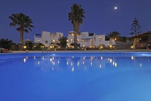 a large swimming pool in front of a house at night at Fragoulis Village in Parasporos