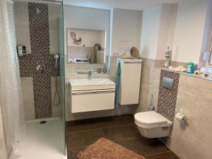 a bathroom with a toilet and a sink and a shower at Cal-ifornia Home 2 in Nuremberg
