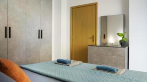 una camera da letto con un letto con lenzuola blu e uno specchio di High-Tech flat a Durrës