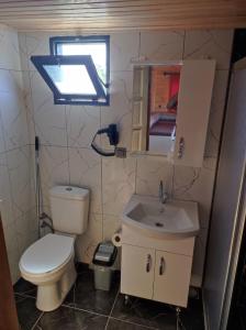 a small bathroom with a toilet and a sink at Ugur Pansiyon Bungalows in Cıralı