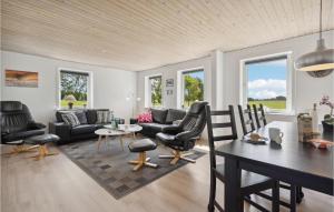 uma sala de estar com um sofá, uma mesa e cadeiras em Cozy Home In Skrbk With Kitchen em Skaerbaek