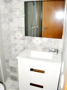 een badkamer met een witte wastafel en een spiegel bij Beverly Hills California in Kenitra