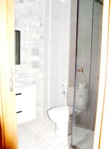 uma casa de banho com um WC e uma cabina de duche em vidro. em Beverly Hills California em Kenitra