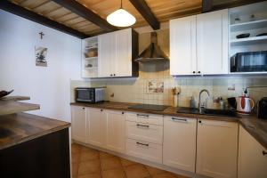 kuchnia z białymi szafkami i zlewem w obiekcie Szum Muzy Ruś Mała w Ostródzie