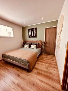 1 dormitorio con 1 cama y suelo de madera en La Villa Vaihéré en Camargue, l'Hibiscus et le Magnolia, en Saintes-Maries-de-la-Mer