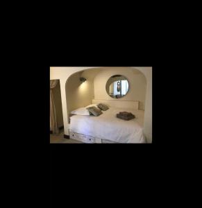um quarto com uma cama branca e um espelho em Maison de village 3 chambres avec petite terrasse em Ramatuelle