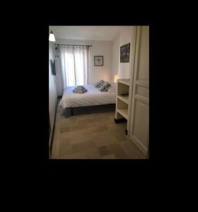 um pequeno quarto com uma cama e uma janela em Maison de village 3 chambres avec petite terrasse em Ramatuelle