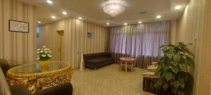 sala de estar con sofá y mesa de cristal en Sebail Inn Hotel en Baku