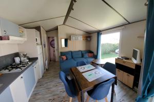 uma cozinha e sala de jantar com uma mesa numa caravana em Mobil Home 5 pers 1 Km de l'Océan em Talmont