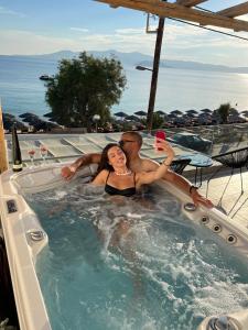 a man and woman in a jacuzzi in a hot tub at Manios Suites in Agia Anna Naxos