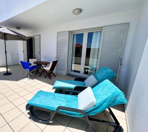 a patio with two chairs and a table on a balcony at Vista Dourada in Porto Santo