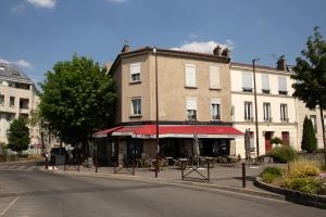 a building with tables and chairs in front of a building at Porte de PARIS , Métro 10 minute à pied Parking gratuit wifi gratuit Netflix in Le Kremlin-Bicêtre