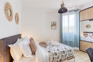 a bedroom with a bed and a large window at KB25 - Métro 14 et le Métro 7 à 6 minutes à pied Emplacement stratégique plus parking gratuit in Le Kremlin-Bicêtre