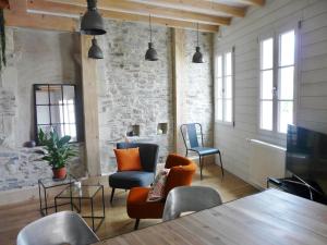 a living room with chairs and a table and windows at Loire Escale in Ancenis