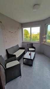 salon z kanapami, stołem i oknami w obiekcie Krk Island Dream: Harbor Walk and Panoramic Views w mieście Porat