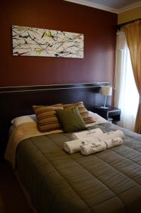1 dormitorio con 1 cama grande y 2 toallas. en Hotel Suite & Spa Verdesolaro en Villa Elisa