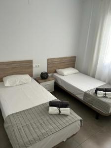 twee bedden in een hotelkamer met handdoeken erop bij AM DEL SOL in Fuengirola