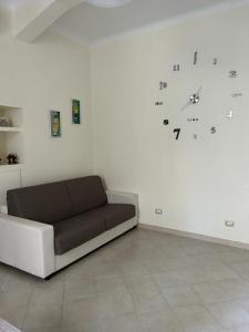 ein Sofa in einem Zimmer mit einer Uhr an der Wand in der Unterkunft Casa Bezzecca La Spezia in La Spezia