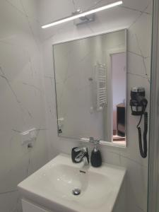 a white bathroom with a sink and a mirror at Sześciu Korsarzy in Dębina