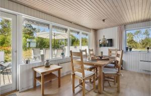 a dining room with a table and chairs and windows at 2 Bedroom Lovely Home In Rm in Kongsmark