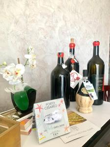 drie flessen wijn zittend op een tafel bij Monolocali White Angel Apartments in Porto Cesareo