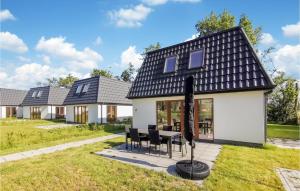 a house with a black roof and a table and chairs at Kavel 17 in Den Oever