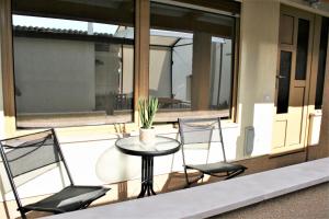 a patio with three chairs and a table with a plant at Small house apartment in Koper