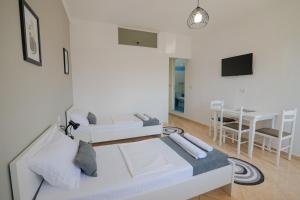 a white room with two beds and a table at Empo Hotel in Ksamil