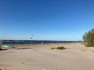 una persona sta volando un aquilone su una spiaggia di Laimdotas a Jūrmala