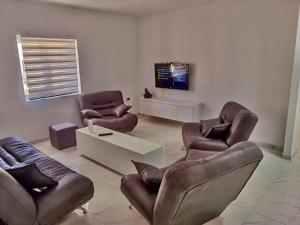 a living room with two leather chairs and a tv at Mimi&Nina in Prović