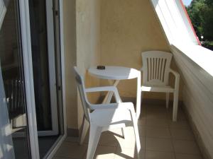 d'une petite table et de deux chaises sur un balcon. dans l'établissement Lenti Thermal Panzió, à Lenti