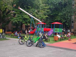 twee fietsen geparkeerd in een park met speeltuin bij Apartman studio MINNA Osijek, free parking in Osijek