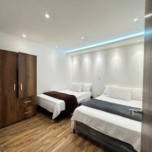 een slaapkamer met 2 bedden en een blauw licht bij Nuevo Apartamento a 3 minutos del JMC de lujo in Rionegro