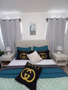 a bedroom with a bed with black and yellow pillows at La Cuna de Moises in Santiago de los Caballeros