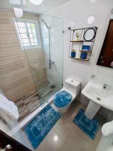 a bathroom with a shower and a toilet and a sink at La Cuna de Moises in Santiago de los Caballeros