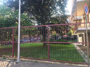 une clôture en métal rouge devant un parc dans l'établissement Casetta Azzurra, à Pero