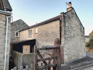 an old brick building with a gate in front of it at Converted Barn in Bath in Bath