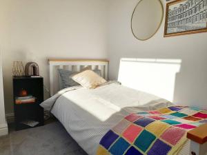 a bedroom with a bed with a colorful comforter at Converted Barn in Bath in Bath