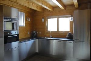 a kitchen with stainless steel appliances and a window at Chalet le Brame en Cevennes in Camprieu