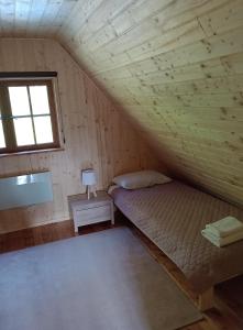 a room with a bed and a window in a attic at Domek letniskowy U Cisków in Mściszewice