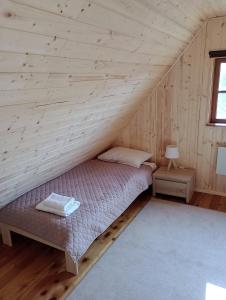 a bedroom with a bed in a log cabin at Domek letniskowy U Cisków in Mściszewice