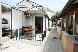 un pequeño edificio con una mesa en una calle en Small house apartment, en Koper