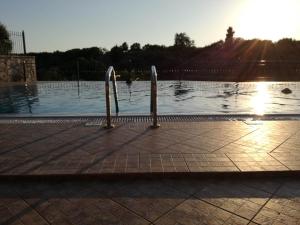 a swimming pool with the sun in the background at Villa Rodanthi Sivota in Syvota