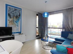 a living room with a blue couch and a tv at Azzurro Sarafovo in Burgas City