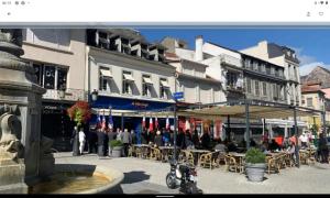 um grupo de pessoas sentadas em mesas fora de um edifício em T2 avec balcon plein sud em Lourdes